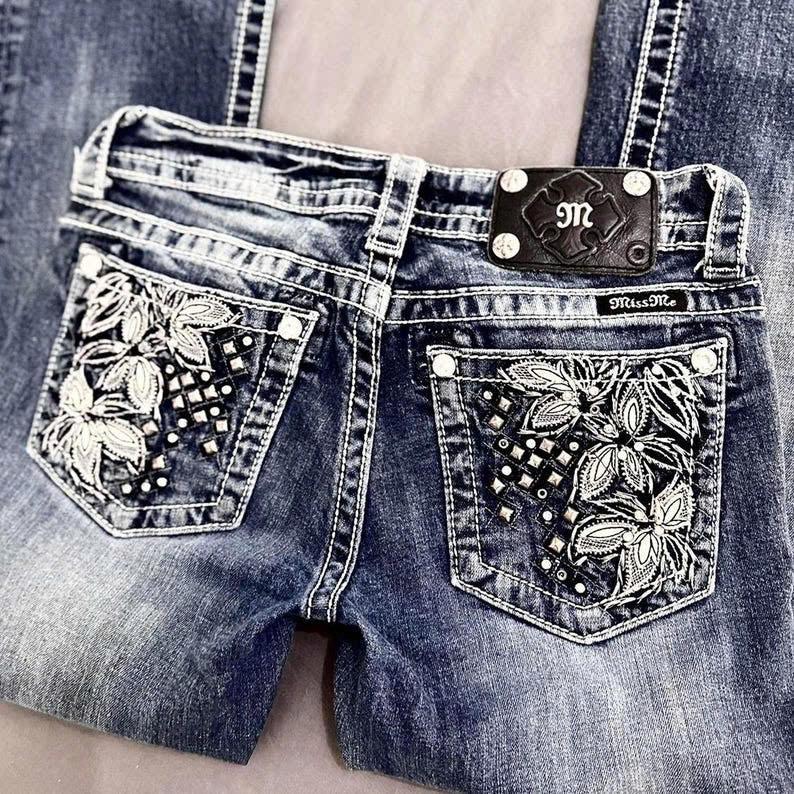 women's bootcut jeans, miss me? 2000’s floral embellished low-rise bootcut jeans. medium-wash vintage grunge mcbling styled piece.